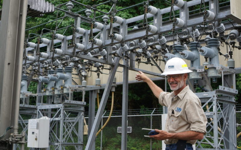 PUD staff pointing at electrical substation