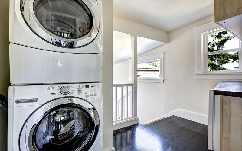 Laundry area with modern white appliances and window