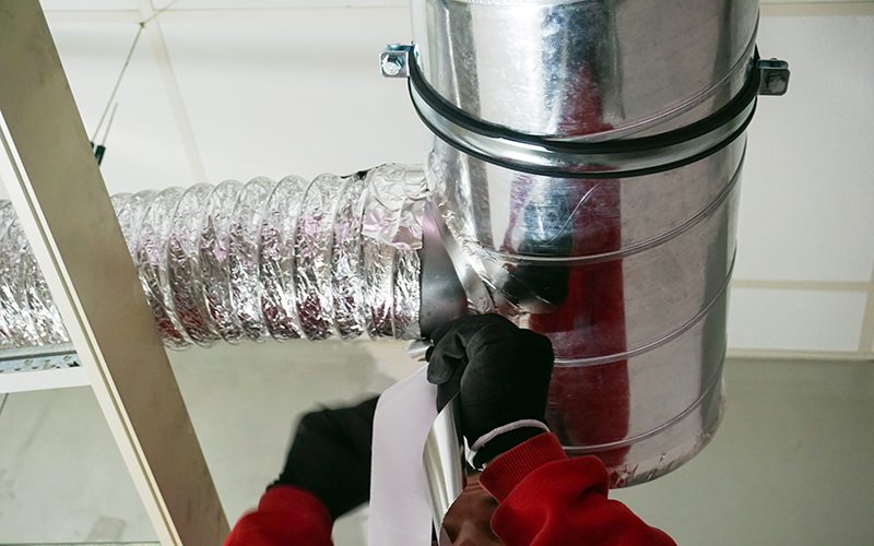 Male hands setting up ventilation system indoors