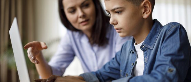 Mother helping teenager with homework