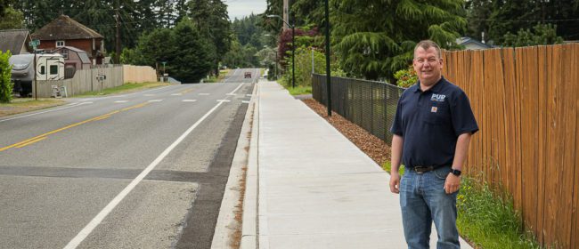 Jimmy Scarborough on the completed sidewalk segment along Cedar Ave.