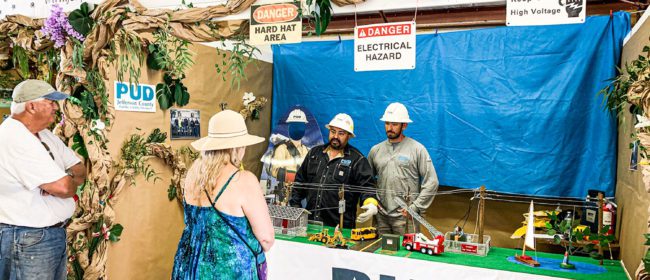 Two PUD staff members managing the PUD Power Town display booth at the fair