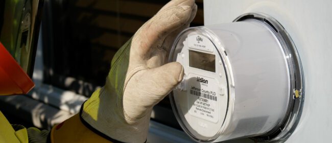 PUD gloved staff member caresses electric meter