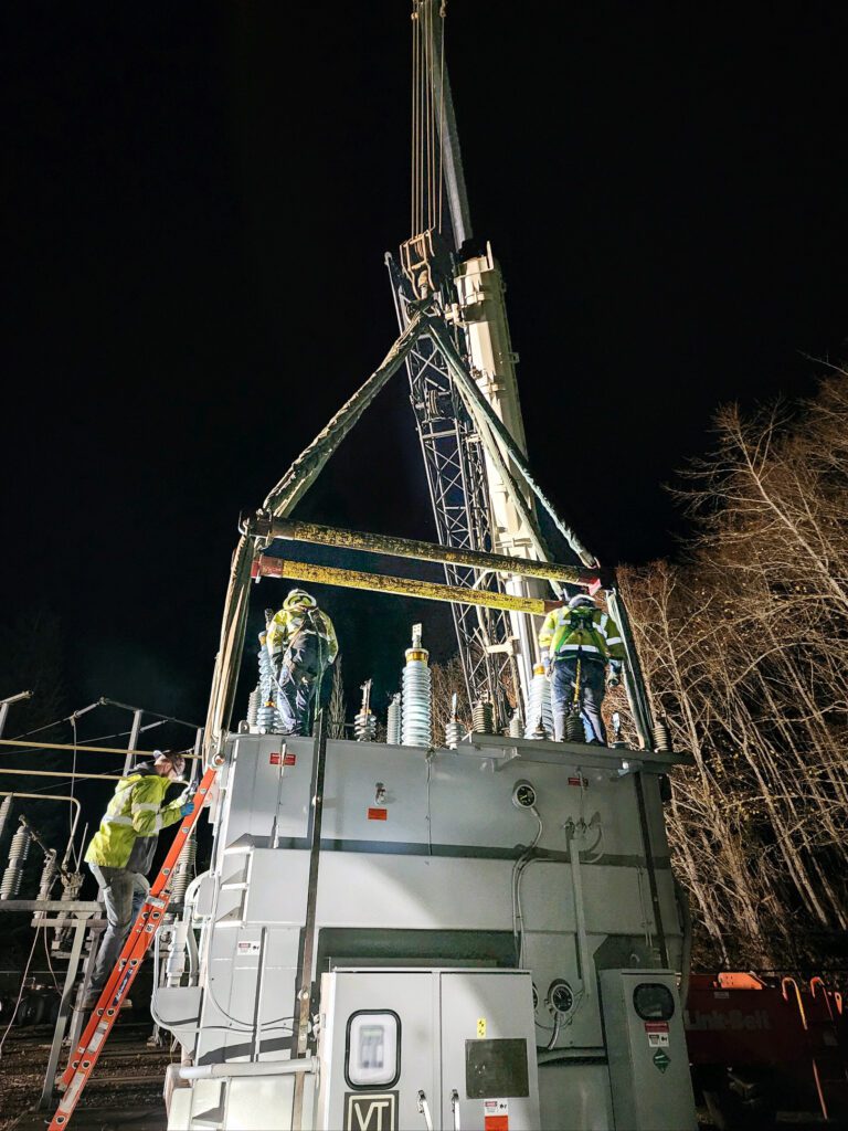 Substation crews working the middle of the night to place a new transformer at the Port Ludlow Substation. Crews climb to the top of the transformer to connect to the system.