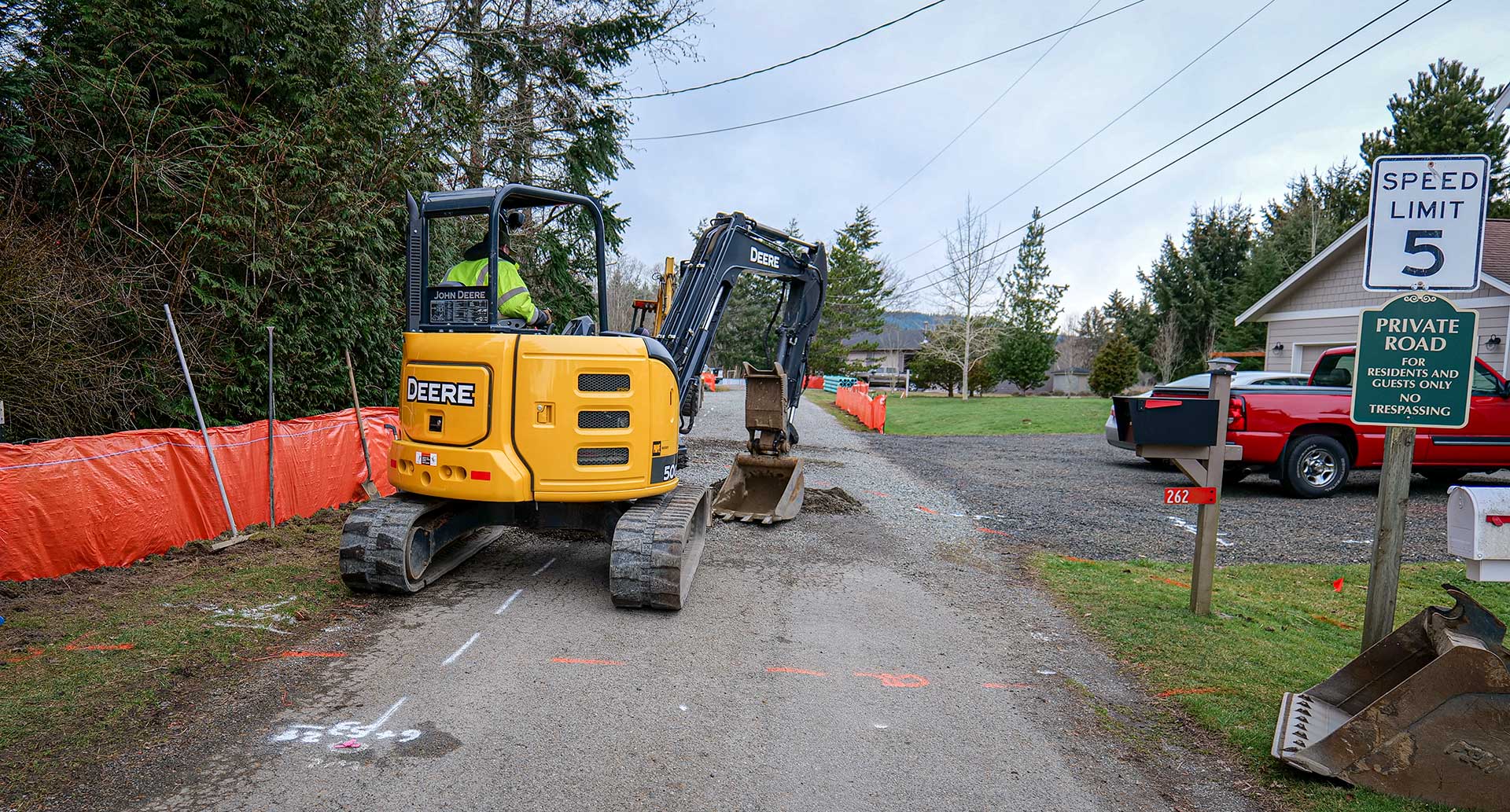 Excavating crew in a backhoe digger prepare for water main replacement work in the Shine area.