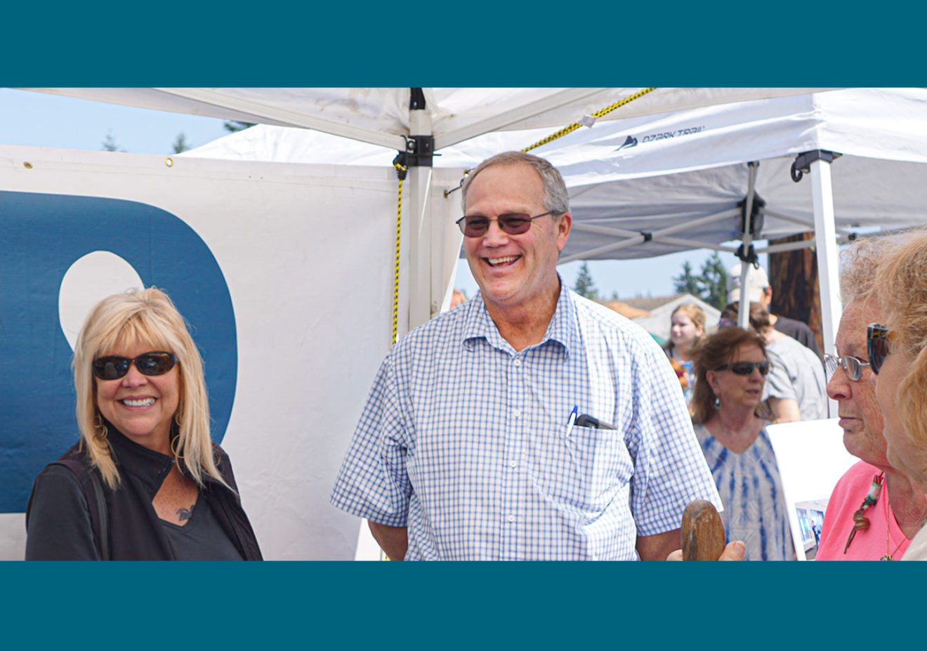 General Manager Kevin Streett smiling and talking with customers at the pUD booth during an outdoor event.