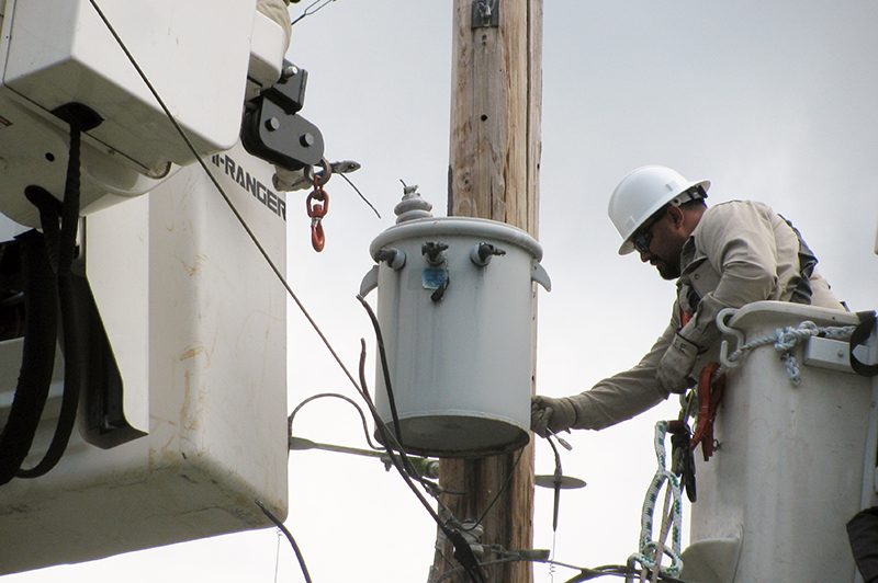 Lineman removing wires from transformer