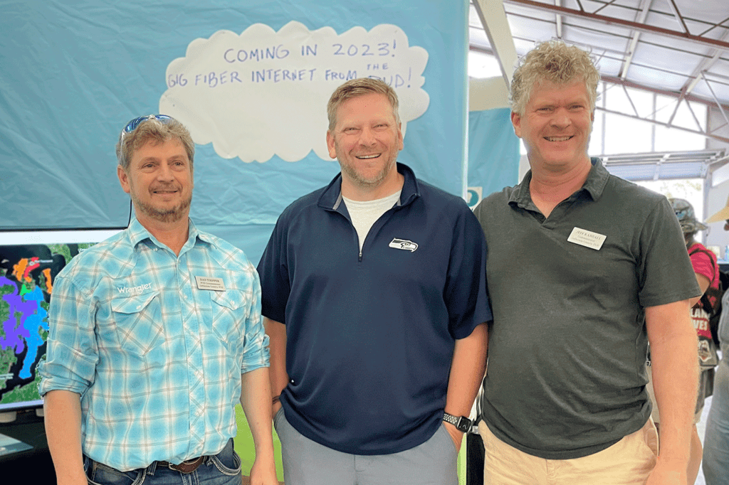 Dan Topper, Mike Chapman and Jeff Randall stand at the Jefferson PUD fair booth in 2022.