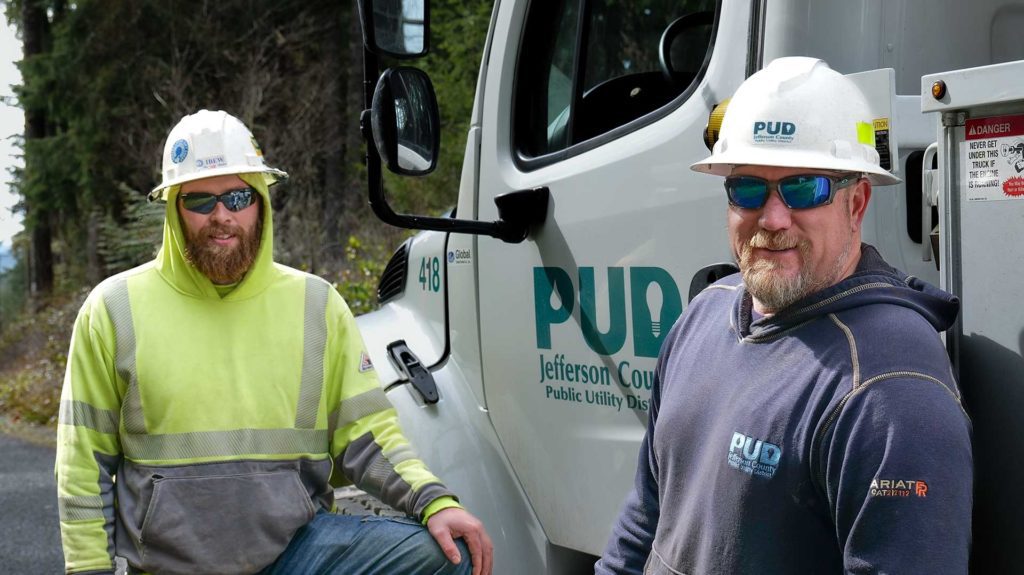 Journeyman Lineman Dylan Brackney (left) and Line Foreman Eric Tharaldsen beside the line truck after placing a distribution pole in the east Quilcene area.