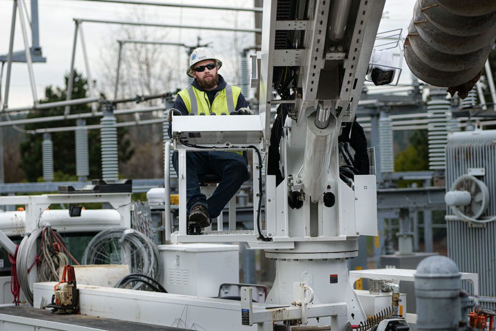 Dylan Brackney controls line truck crane as the crew places a new regulator at the Dana Roberts substation in PT.