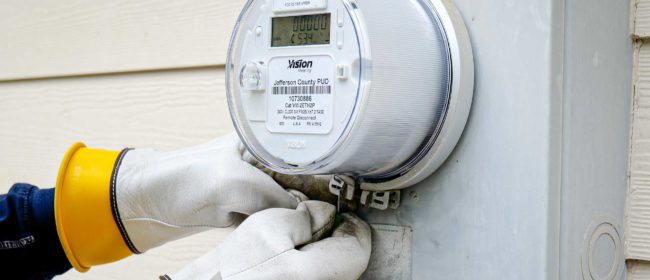 Meter reader applies an anti-tamper tag to the newly-installed AMI meter on a home.