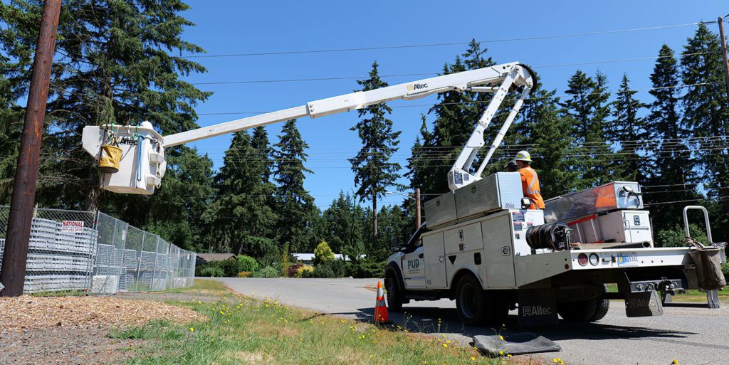 Bucket rescue (2022 training) underway with a hardhat just visible at the top of the bucket. Crews must navigate getting the bucket safely from the hazard zone to the ground while controlling from the line truck.