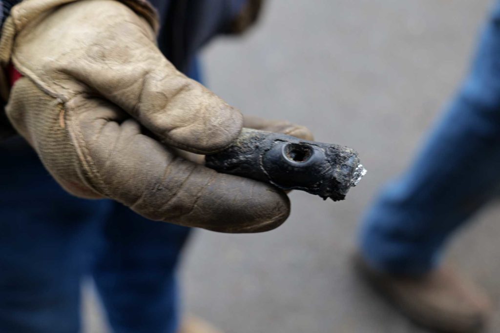 Line crew member holds a section of damaged underground cable.