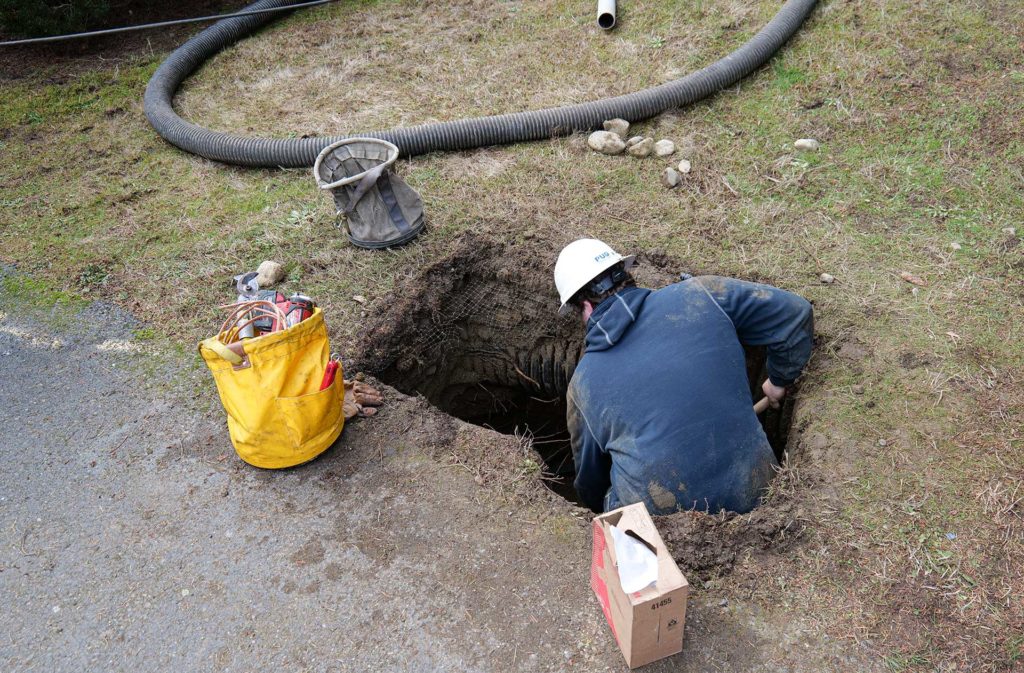 Line crew team member hand digs around underground fault.