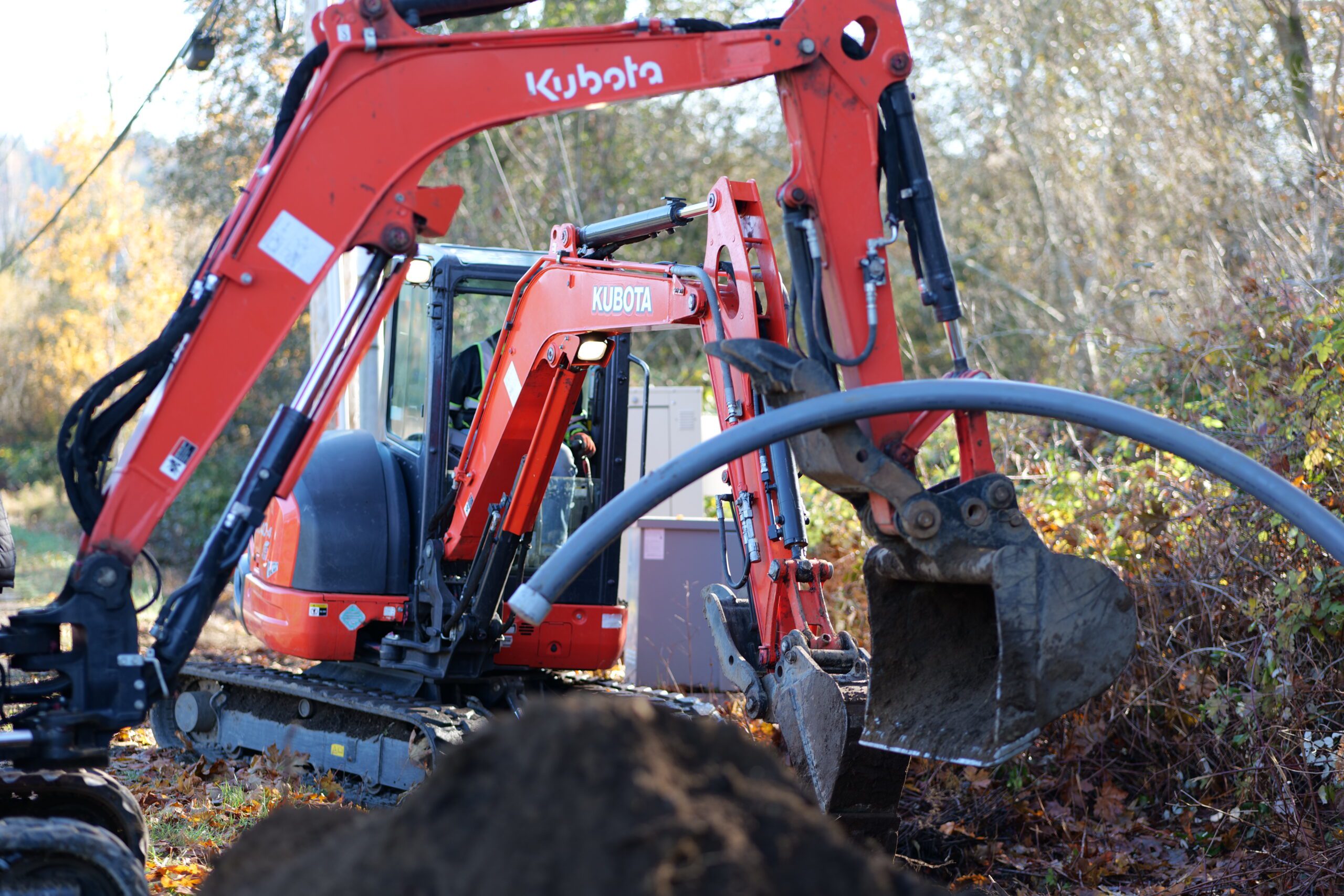 Contract crew from the PUD small work roster use small excavators to trench conduit for under grounding work.
