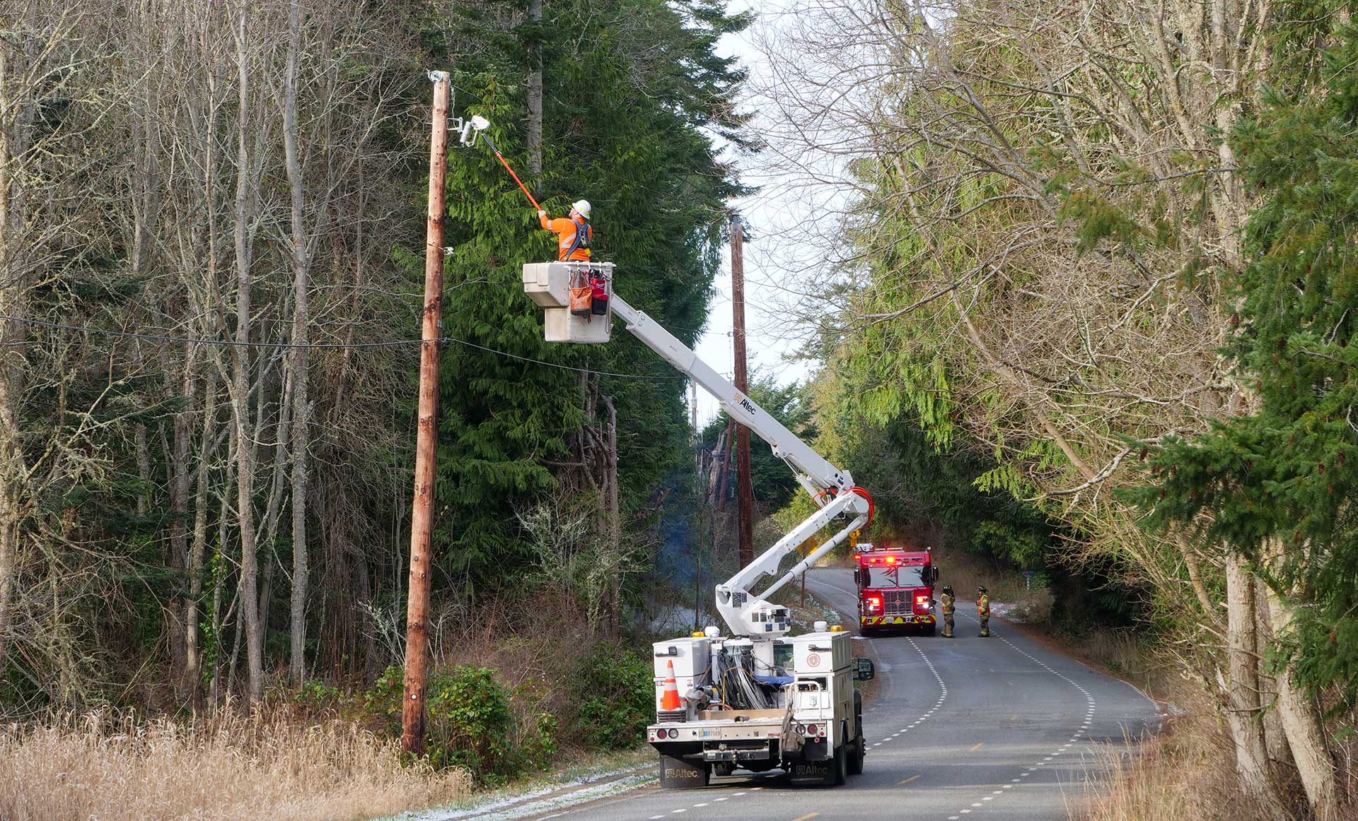 PUD line worker removes a pole cutout to de-energize a down line.