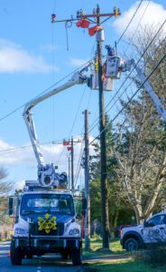 Line crew in two bucket trucks work to mount hardware to a new pole installed in Port Townsend.