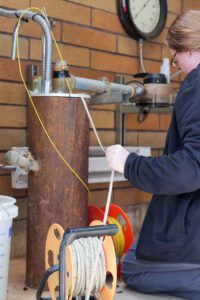 Cheyenne Stice carefully documents water level intervals on. clipboard during the pump test well sounding.