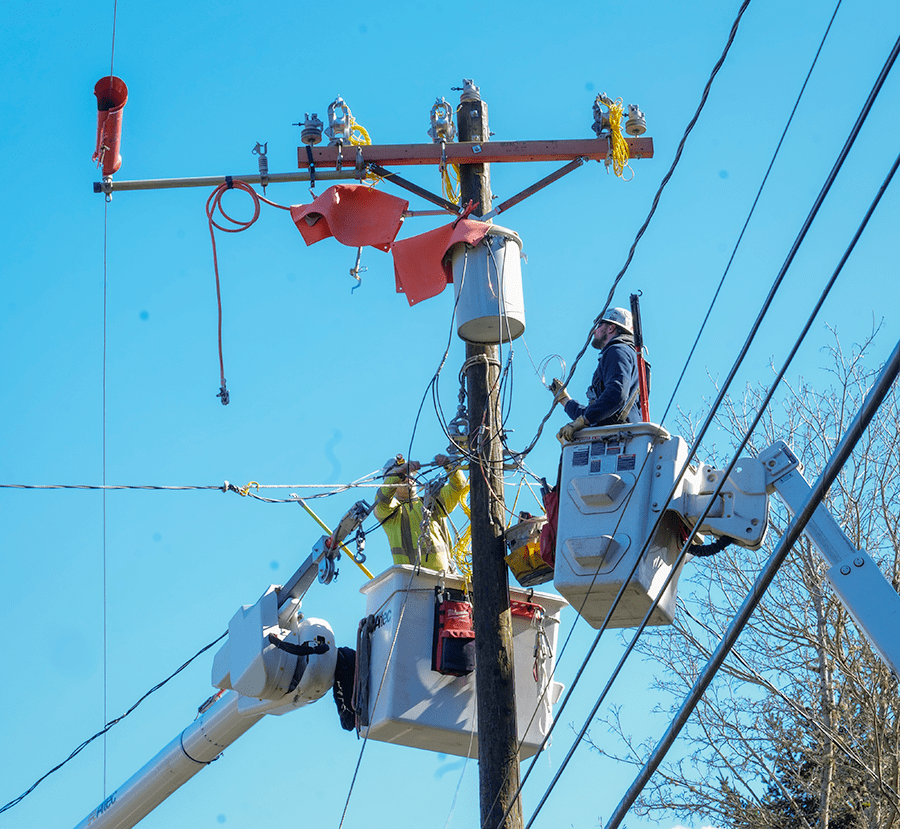 Line crew in bucket truck bucks work on a distribution pole with a pole mounted transformer.