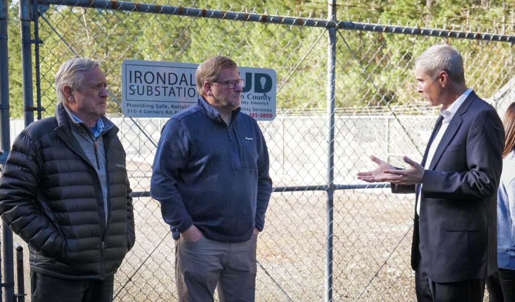 representative and senator talking to PUD general manager outside substation.