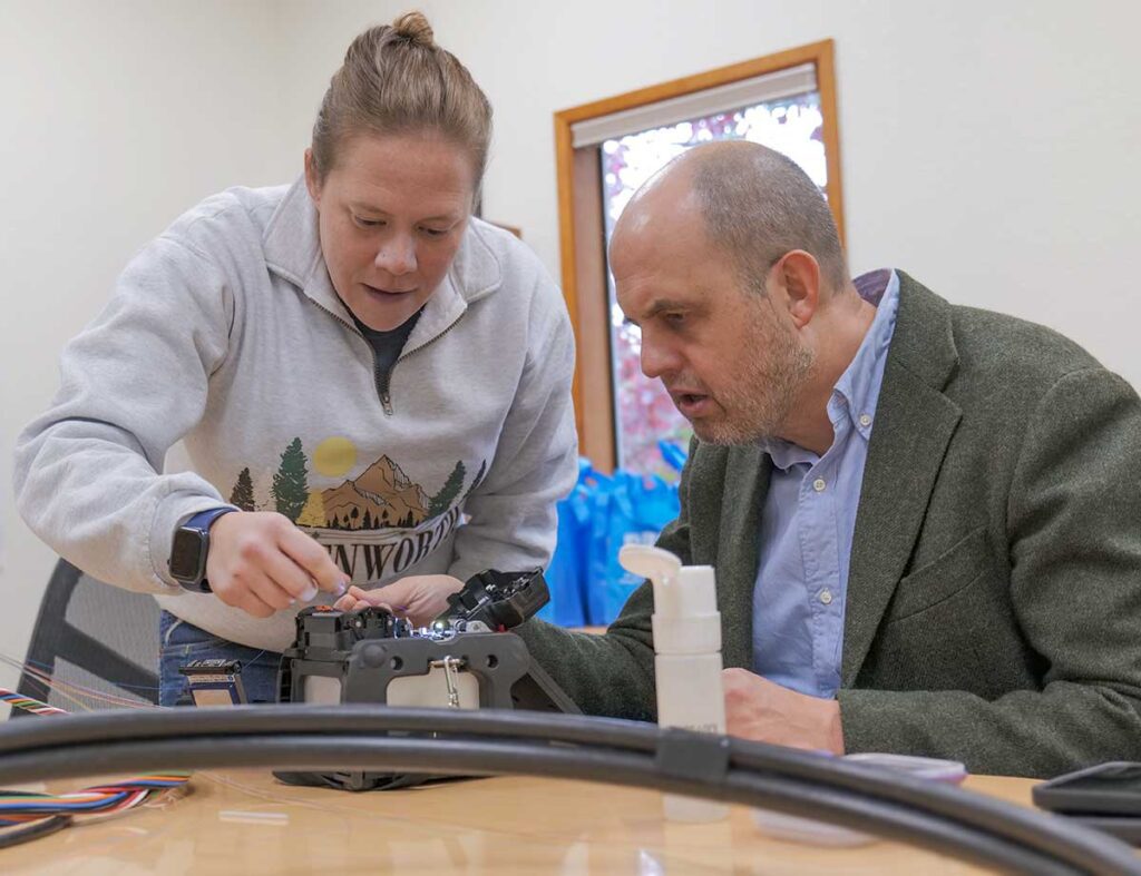WA State Senator, Drew Hansen, completes a fiber splice during a demo at Jefferson PUD's broadband office.