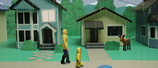 image of clay and cardboard model with two characters on a sidewalk on a rainy day walking past houses and a deer